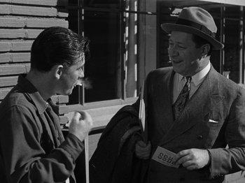 Movie still from “The Reluctant Dragon” (1941), directed by Jack Cutting – Two men talking to each other outside a building; Medium shot, Over the shoulder angle