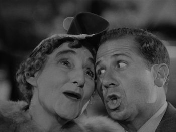 Movie still from “The Reluctant Dragon” (1941), directed by Jack Cutting – An older woman and a younger man looking at each other; Close Up shot, High angle