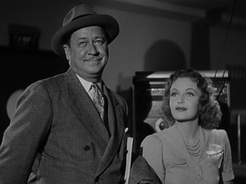 Movie still from “The Reluctant Dragon” (1941), directed by Jack Cutting – An old photo of a man and a woman posing for a picture; Medium shot, Low angle