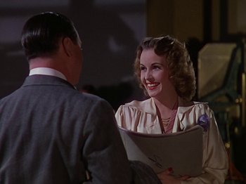 Movie still from “The Reluctant Dragon” (1941), directed by Jack Cutting – An older woman smiles as she talks to an older man; Medium shot, Over the shoulder angle