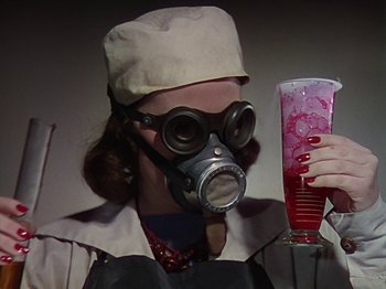 Movie still from “The Reluctant Dragon” (1941), directed by Jack Cutting – A woman wearing a gas mask and holding a drink; Medium shot, Low angle