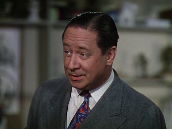 Movie still from “The Reluctant Dragon” (1941), directed by Jack Cutting – A person wearing a suit and tie; Close Up shot, High angle