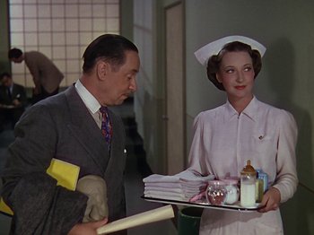 Movie still from “The Reluctant Dragon” (1941), directed by Jack Cutting – A man and a woman holding a tray in a room; Medium shot, Low angle