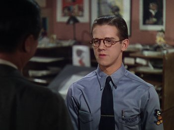 Movie still from “The Reluctant Dragon” (1941), directed by Jack Cutting – A young man wearing glasses and a tie; Close Up shot, Over the shoulder angle