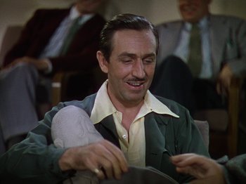 Movie still from “The Reluctant Dragon” (1941), directed by Jack Cutting – A man sitting in front of a group of people; Medium shot, Over the shoulder angle