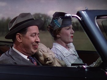 Movie still from “The Reluctant Dragon” (1941), directed by Jack Cutting – A man and a woman sitting in the back of a car; Medium shot, Low angle