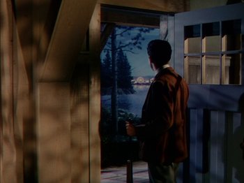 Movie still from “The Snows of Kilimanjaro” (1952), directed by Henry King – A man standing in front of an open window; Wide shot, Low angle