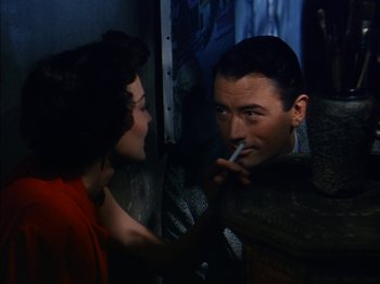 Movie still from “The Snows of Kilimanjaro” (1952), directed by Henry King – A man smoking a cigarette next to a woman; Medium shot, High angle