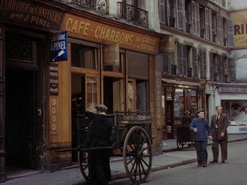 Movie still from “The Snows of Kilimanjaro” (1952), directed by Henry King – An old photo of a street scene with a horse and carriage; Wide shot, High angle