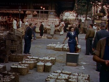 Movie still from “The Snows of Kilimanjaro” (1952), directed by Henry King – A group of people standing in a market area; Wide shot, High angle