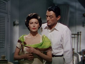 Movie still from “The Snows of Kilimanjaro” (1952), directed by Henry King – A man and a woman standing next to each other in a room; Medium shot, Low angle