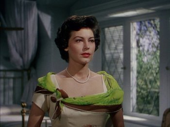 Movie still from “The Snows of Kilimanjaro” (1952), directed by Henry King – A woman in a green and white dress with a necklace around her neck; Close Up shot, Low angle
