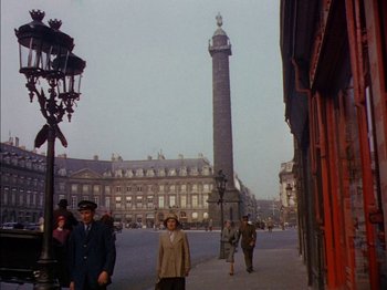 Movie still from “The Snows of Kilimanjaro” (1952), directed by Henry King – People are walking down the street near a tall tower; Extreme Wide shot, High angle