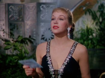 Movie still from “The Snows of Kilimanjaro” (1952), directed by Henry King – A woman in a black dress holding a piece of paper in her hand; Close Up shot, Low angle