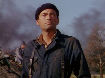 Movie still from “The Snows of Kilimanjaro” (1952), directed by Henry King – A man wearing a black hat and a black jacket; Medium shot, Low angle