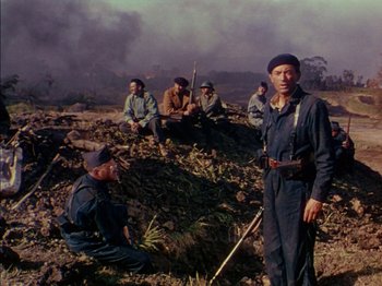Movie still from “The Snows of Kilimanjaro” (1952), directed by Henry King – A group of men sitting on top of a grass covered field; Wide shot, Low angle