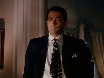 Movie still from “The Snows of Kilimanjaro” (1952), directed by Henry King – A man in a black suit and a black and white polka dot neck tie; Close Up shot, Low angle