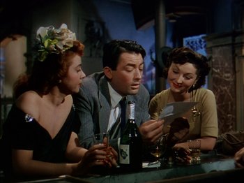 Movie still from “The Snows of Kilimanjaro” (1952), directed by Henry King – A man and two women sitting at a bar; Medium shot, Low angle