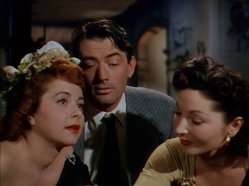 Movie still from “The Snows of Kilimanjaro” (1952), directed by Henry King – A man and two women sitting next to each other; Close Up shot, Over the shoulder angle