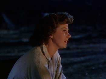 Movie still from “The Snows of Kilimanjaro” (1952), directed by Henry King – A woman sitting on the ground in the dark; Close Up shot, Low angle