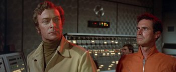 Movie still from “The Swarm” (1978), directed by Irwin Allen – A man standing in front of a control panel; Medium shot, Low angle