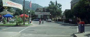 Movie still from “The Swarm” (1978), directed by Irwin Allen – A group of people riding bikes down a street; Extreme Wide shot, High angle