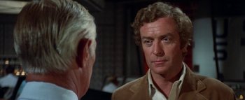 Movie still from “The Swarm” (1978), directed by Irwin Allen – A man looking at himself in the mirror in front of another man; Close Up shot, Over the shoulder angle