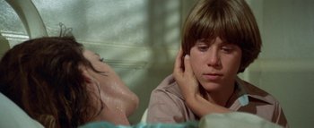 Movie still from “The Swarm” (1978), directed by Irwin Allen – A young boy sitting in front of a woman; Close Up shot, Over the shoulder angle
