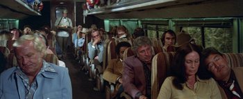 Movie still from “The Swarm” (1978), directed by Irwin Allen – A group of people sitting on a train; Wide shot, High angle