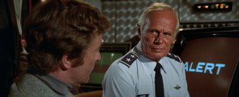 Movie still from “The Swarm” (1978), directed by Irwin Allen – A man in uniform talking to another man in uniform; Close Up shot, Over the shoulder angle