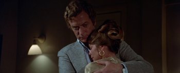 Movie still from “The Swarm” (1978), directed by Irwin Allen – A man and a woman embracing each other in front of a door; Close Up shot, Over the shoulder angle
