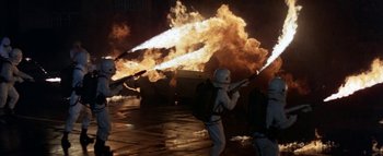 Movie still from “The Swarm” (1978), directed by Irwin Allen – A person in a white suit holding a gun; Wide shot, High angle