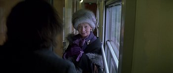 Movie still from “The Truth About Charlie” (2002), directed by Jonathan Demme – An older woman wearing a fur hat on a train; Close Up shot, Over the shoulder angle