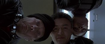 Movie still from “The Truth About Charlie” (2002), directed by Jonathan Demme – Two men standing next to each other in front of a window; Close Up shot, Overhead angle