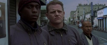 Movie still from “The Truth About Charlie” (2002), directed by Jonathan Demme – Two men standing next to each other on the street; Close Up shot, Low angle