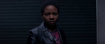 Movie still from “The Truth About Charlie” (2002), directed by Jonathan Demme – A woman wearing a black leather jacket and a pink shirt; Close Up shot, Low angle