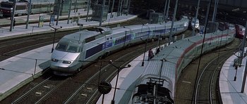 Movie still from “The Truth About Charlie” (2002), directed by Jonathan Demme – Several trains on the tracks at a train station; Extreme Wide shot, High angle