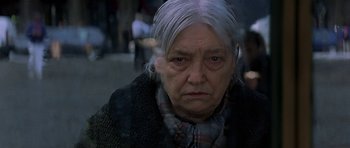 Movie still from “The Truth About Charlie” (2002), directed by Jonathan Demme – An old woman with a gray hair and a plaid scarf; Close Up shot, Low angle