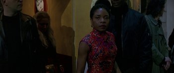 Movie still from “The Truth About Charlie” (2002), directed by Jonathan Demme – A woman in a red and black dress standing in front of a mirror; Medium shot, Over the shoulder angle