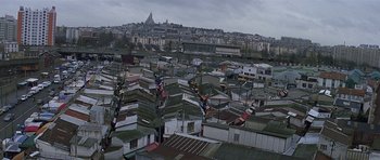 Movie still from “The Truth About Charlie” (2002), directed by Jonathan Demme – An aerial view of a city with many buildings; Extreme Wide shot, High angle