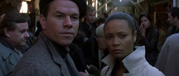 Movie still from “The Truth About Charlie” (2002), directed by Jonathan Demme – A man and a woman standing next to each other in a crowd; Close Up shot, Low angle