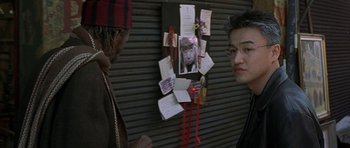 Movie still from “The Truth About Charlie” (2002), directed by Jonathan Demme – Two people standing in front of a bulletin board with pictures and notes on it; Close Up shot, Over the shoulder angle