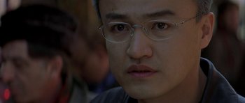 Movie still from “The Truth About Charlie” (2002), directed by Jonathan Demme – A person wearing glasses and looking at the camera; Close Up shot, Low angle