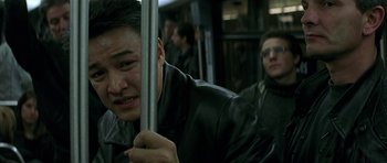 Movie still from “The Truth About Charlie” (2002), directed by Jonathan Demme – A man holding onto the handle of a bus; Close Up shot, Low angle