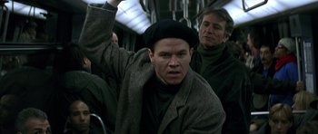 Movie still from “The Truth About Charlie” (2002), directed by Jonathan Demme – A man in a hat and coat on a bus; Medium shot, Low angle