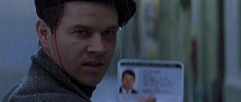 Movie still from “The Truth About Charlie” (2002), directed by Jonathan Demme – A man holding up a photo of himself; Close Up shot, Low angle