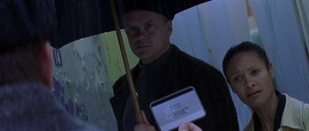 Movie still from “The Truth About Charlie” (2002), directed by Jonathan Demme – A man holding an umbrella over his head; Close Up shot, High angle