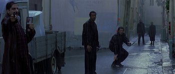 Movie still from “The Truth About Charlie” (2002), directed by Jonathan Demme – Two men are standing in a dark room; Wide shot, High angle