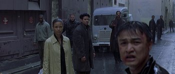 Movie still from “The Truth About Charlie” (2002), directed by Jonathan Demme – A group of people standing in front of a truck; Medium shot, Over the shoulder angle