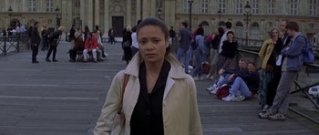 Movie still from “The Truth About Charlie” (2002), directed by Jonathan Demme – A woman standing in front of a group of people; Medium shot, High angle